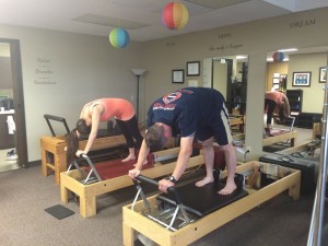 Two People Participating in a Reformer Pilates Class